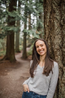 headshot_3_about me Close up shot of Breanna Owen, Licensed and Certified Mental Health Counselor leaning against a tree.